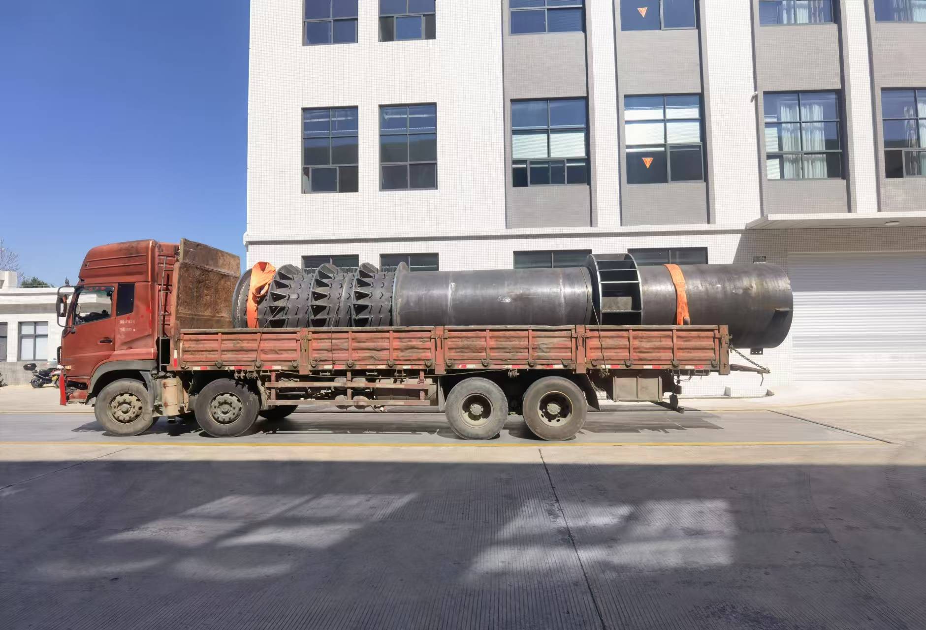 Large diameter tubular steel columns loaded onto a truck for delivery