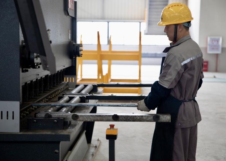 Operator feeding a steel section through a section processing machine