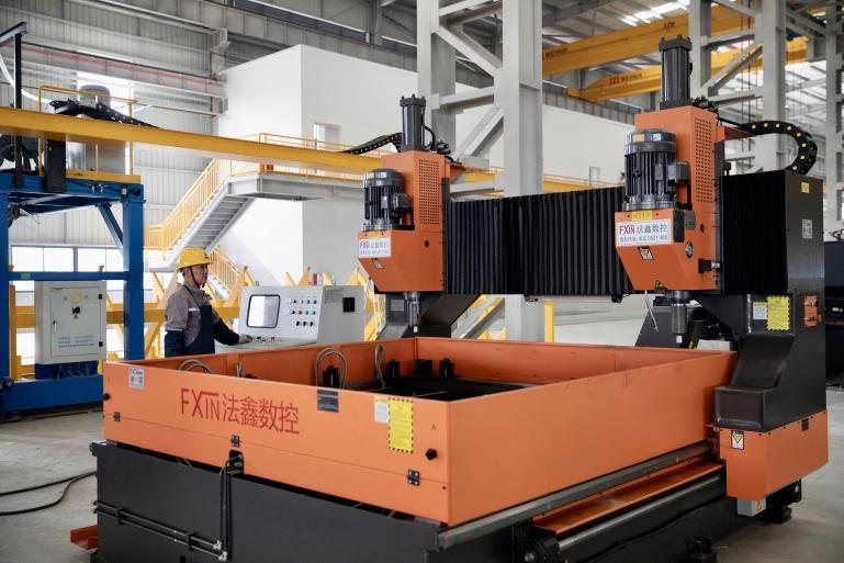 Automated machine processing a fabricated steel section